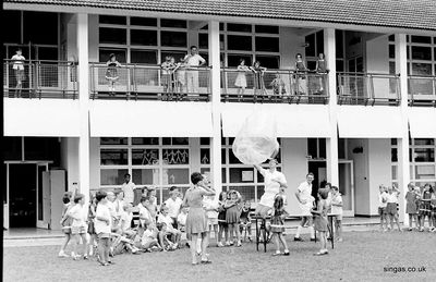 Tony Webb and a colleague experimenting with a hot air balloon
Tony Webb and a colleague experimenting with a hot air balloon. Look at those girls standing on the railing: wouldn't be allowed, under Health and Safety, nowadays! That's Peter Drury up there with them and the deputy Head, Gwyn Jones, walking away but still watching.
Keywords: Bill Johnston;Wessex Junior;Pasir Panjang Junior;School;Tony Webb;Peter Drury;Gwyn Jones
