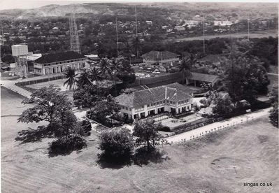 Aerial view of RNWS Kranji circa 1971
Aerial view of RNWS Kranji circa 1971.  The large building closest to the shot was the PMO's "bungalow". Beyond it are the tennis courts and the swimming pool which you can just see surrounded by seats and umbrellas. The large aerial is the microwave aerial. In front of it is a barracks. A similar one off shot was converted to an Australian social club and called "the Geoff Childs Club!" after my Dad!
Keywords: Lucy Childs;RNWS Kranji;1971;Aerial;Geoff Childs