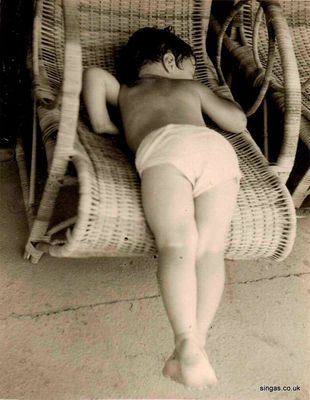 Me refusing to have my photo taken
Me refusing to have my photo taken lying on one of the poolside rattan chairs. The Kranji pool was just a short walk up the hill from our bungalow. We spent a lot of our time here. Once I was bitten on the face by a piedog and another time I got some glass embedded in my foot. Each time I was driven to the local medical centre in a dustcart!
Keywords: Lucy Childs;Kranji pool