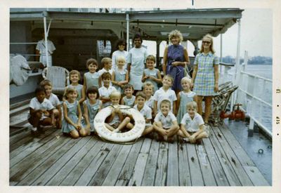 West Coast Inf. class 5 Fort Rosalie Sept 1970
This was taken on board an RFA ammunition ship called Fort Rosalie.  On the scan image are the names of some of the children in their own handwriting.  The tall teacher in the middle was the head of the school, and Margaret (a teacher) is on the right.

Margaret said that this little group were about 5-6 years old in September 1970, and that they all left school at the end of term together to return to UK.
Keywords: West Coast Infants;Fort Rosalie;1970