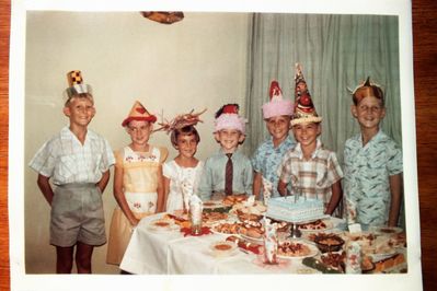 One of my birthday parties.
I am the one on the left of the boy in the clown hat. Of the children there the only name I remember is of the boy on the extreme right who could only see out of his right eye and he was named William. He lived in the flat above us in Cambrai Court.
