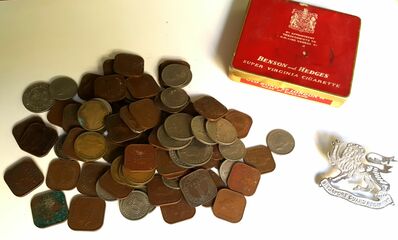 Some Malayan coinage, B&H cigarette tin and a Singapore Guard Regiment cap badge
